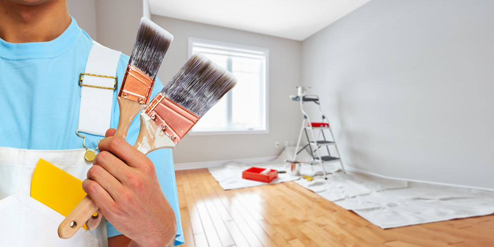 painter holding paint brushes